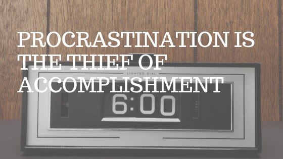 an old-timey clock radio in a wood paneled room. White text over picture reading "procrastination is the thief of accomplishment" 