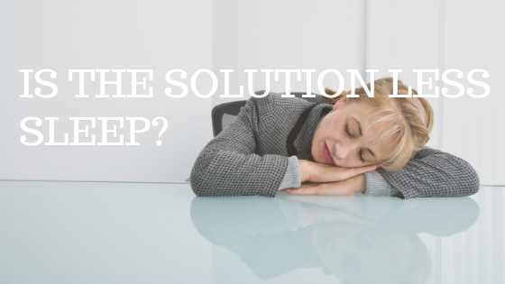 woman in grey suit taking nap on glass desk with white text reading "is the solution more sleep"